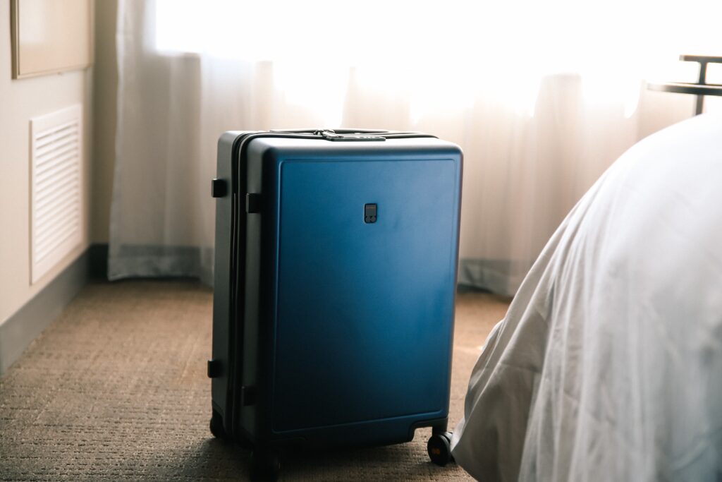 Blue Pull Suitcase In Bedroom
