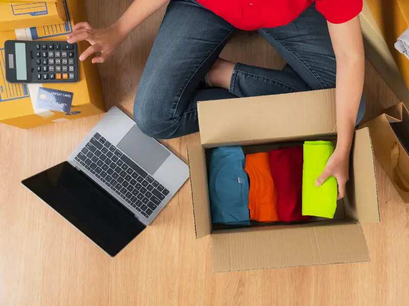 Person checking order as they pack clothes into boxes